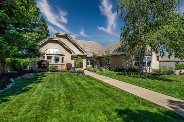 view of front of home featuring a front yard and stucco siding