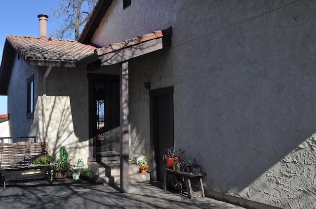 exterior space with a tile roof, a patio, and stucco siding