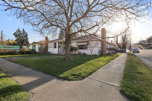 view of front of property with a chimney and a front yard