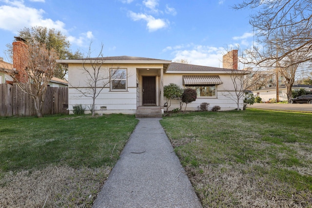 view of front of property with a chimney, crawl space, fence, a front yard, and stucco siding