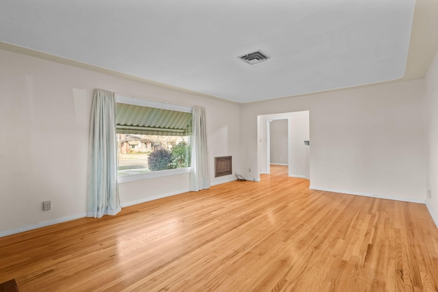 spare room with baseboards, visible vents, and light wood-style floors