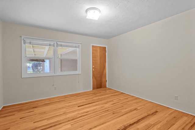spare room featuring a textured ceiling and wood finished floors