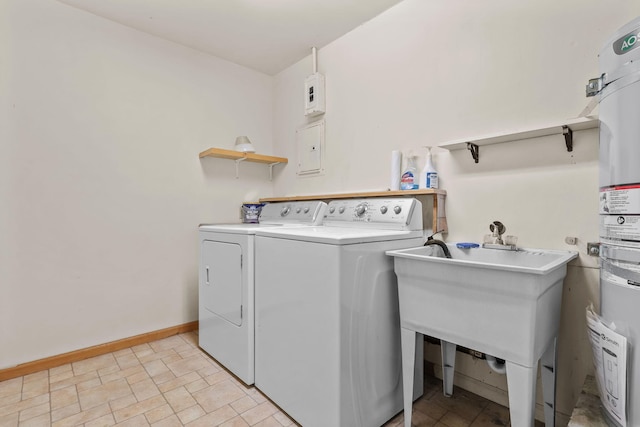 washroom with laundry area, baseboards, independent washer and dryer, stone finish flooring, and water heater
