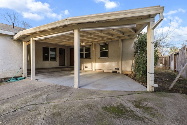 view of patio / terrace featuring an attached carport and fence
