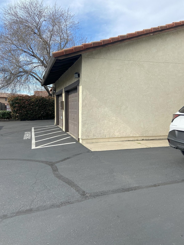 view of home's exterior with a garage, an outbuilding, and stucco siding