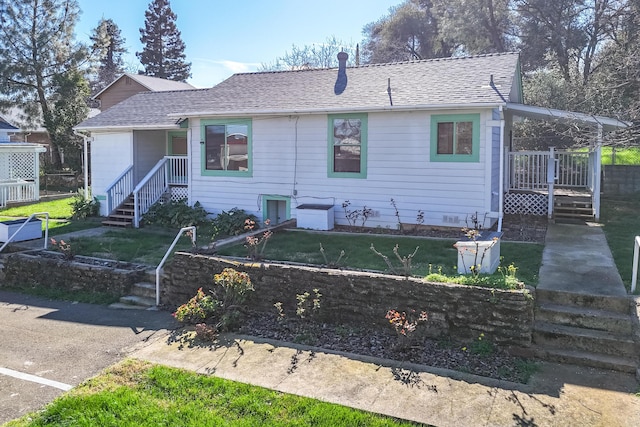 single story home featuring a front lawn, roof with shingles, and an attached carport