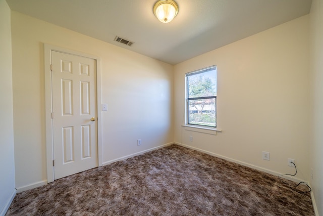 empty room featuring baseboards, visible vents, and carpet flooring