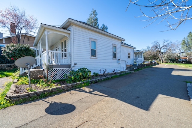 view of side of property with covered porch