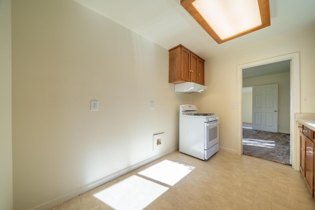 kitchen with white gas range, light countertops, brown cabinetry, under cabinet range hood, and baseboards