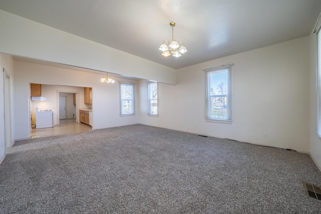 unfurnished living room featuring light carpet, visible vents, and a notable chandelier