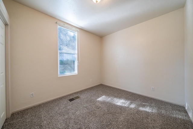 carpeted empty room with baseboards and visible vents