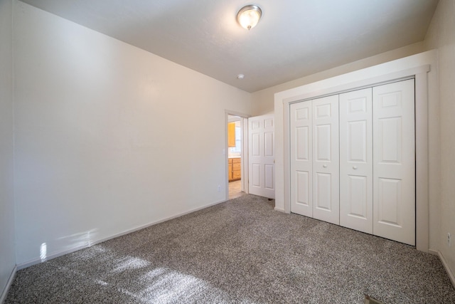 unfurnished bedroom featuring carpet, a closet, and baseboards