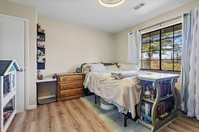 bedroom featuring visible vents and wood finished floors