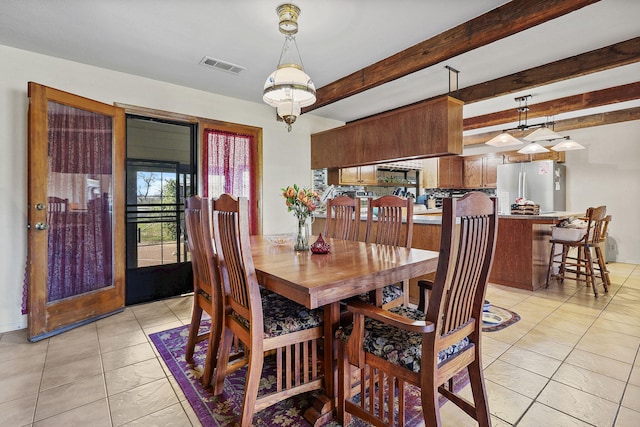 dining space with light tile patterned floors, visible vents, and beamed ceiling