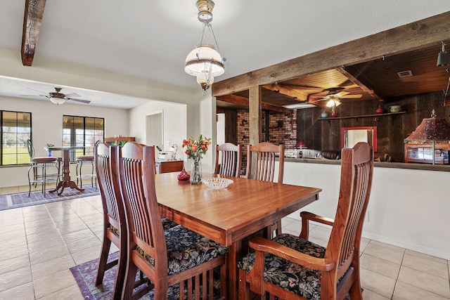 dining space with tile patterned flooring, visible vents, a ceiling fan, and beamed ceiling