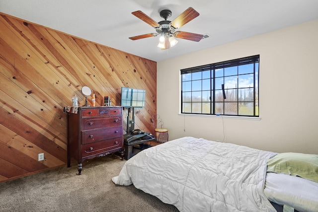 bedroom featuring ceiling fan, carpet floors, and wooden walls