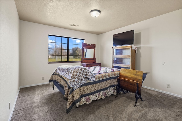 carpeted bedroom featuring a textured ceiling, visible vents, and baseboards