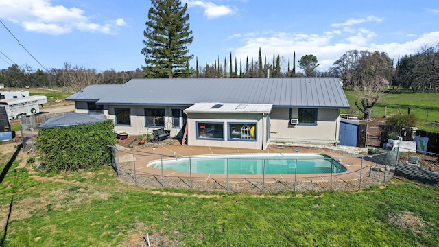 back of property featuring a yard, fence, and a fenced in pool