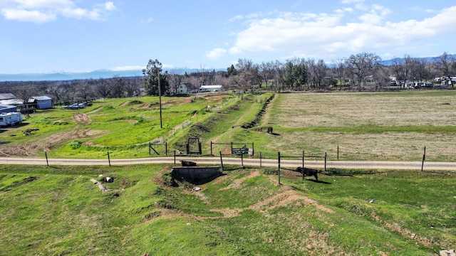 view of community with a rural view and fence