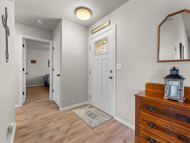 foyer featuring baseboards and light wood finished floors