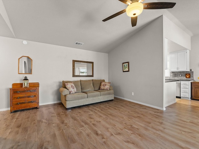 living room featuring light wood-style flooring, baseboards, and lofted ceiling