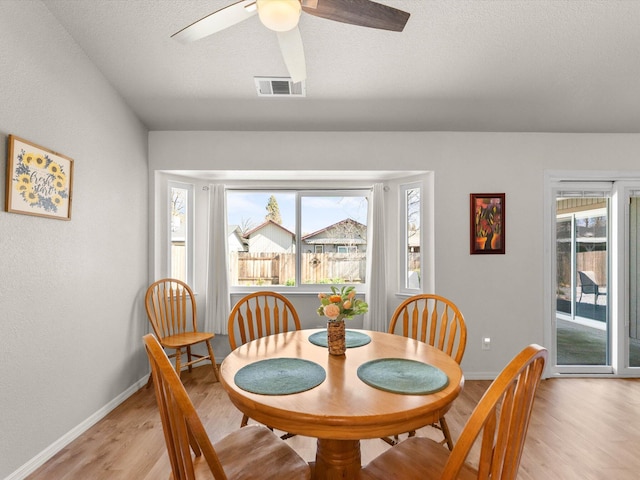 dining room featuring plenty of natural light, baseboards, visible vents, and light wood finished floors