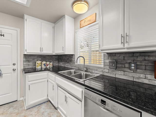 kitchen featuring white cabinetry, dark stone counters, a sink, stainless steel dishwasher, and tasteful backsplash