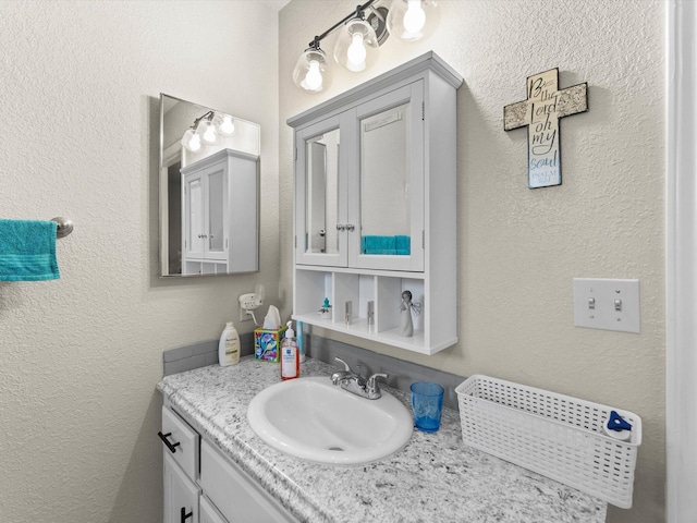 bathroom with vanity and a textured wall