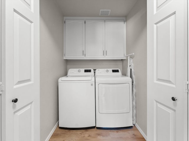 clothes washing area with light wood finished floors, visible vents, baseboards, cabinet space, and independent washer and dryer