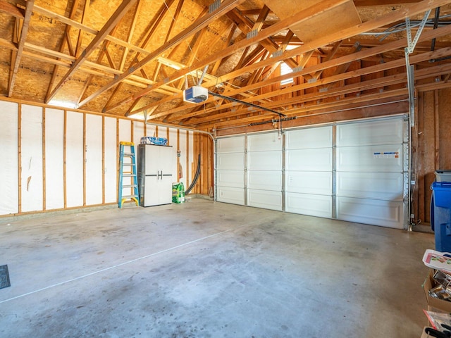 garage with freestanding refrigerator and a garage door opener