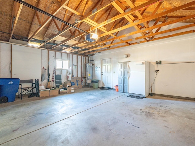 garage with secured water heater, a garage door opener, and freestanding refrigerator