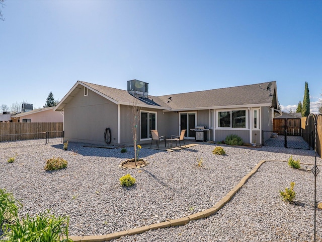 rear view of property featuring a patio, central AC unit, and a fenced backyard