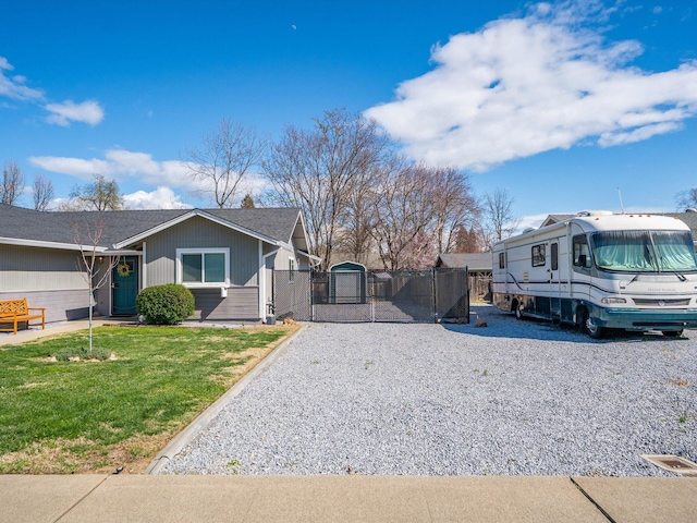 view of front of house featuring fence, a shingled roof, a front yard, and a gate