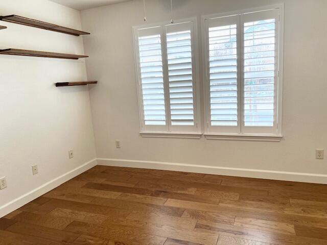 unfurnished room with wood finished floors and baseboards