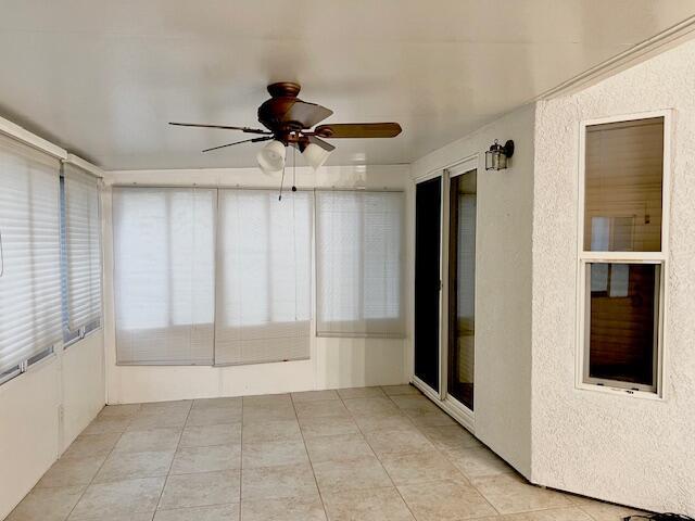 unfurnished sunroom with a ceiling fan