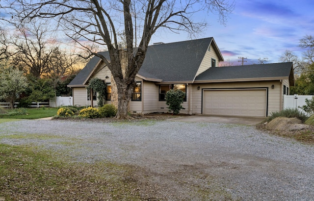 view of front of house featuring gravel driveway, a shingled roof, an attached garage, crawl space, and fence