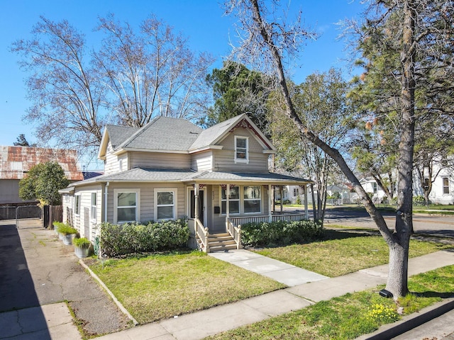 view of front of property with roof with shingles, a porch, and a front lawn