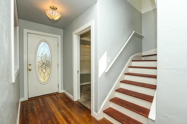 foyer entrance featuring stairs, baseboards, and wood finished floors