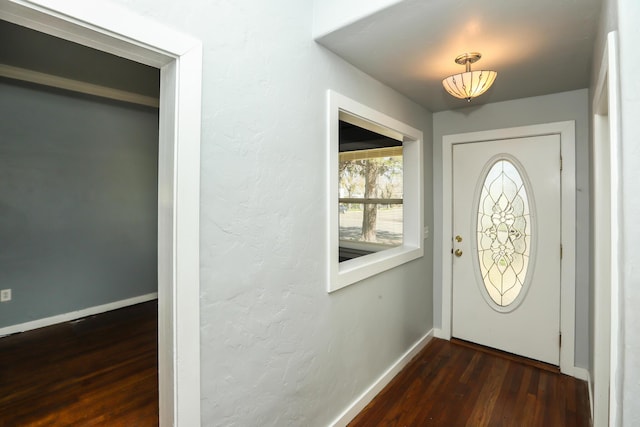 entrance foyer with dark wood-type flooring and baseboards