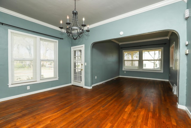 unfurnished room featuring arched walkways, ornamental molding, and baseboards