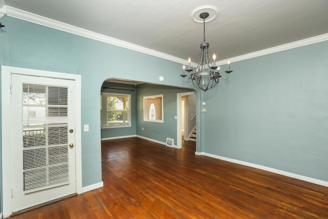 spare room featuring ornamental molding, arched walkways, stairway, and wood finished floors