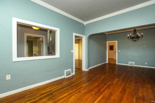 unfurnished room featuring baseboards, visible vents, wood finished floors, and ornamental molding