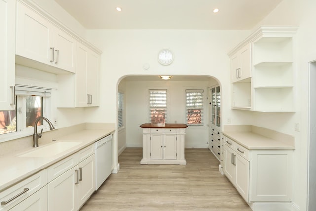 kitchen featuring white cabinets, dishwasher, light wood-type flooring, a sink, and recessed lighting