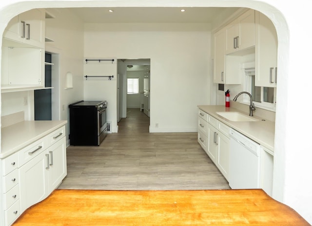 kitchen featuring light countertops, dishwasher, electric range, and a sink