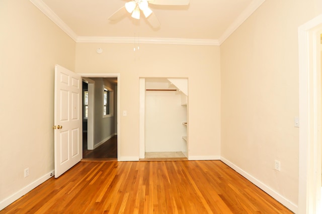 unfurnished bedroom featuring light wood-style floors, crown molding, and baseboards