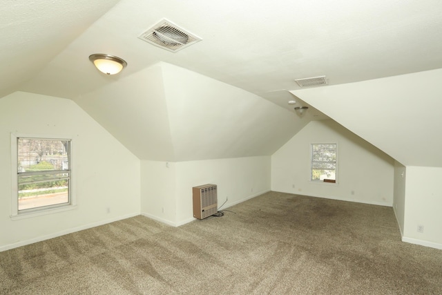 additional living space with vaulted ceiling, carpet, and visible vents