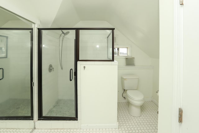 bathroom with toilet, a shower stall, baseboards, and lofted ceiling