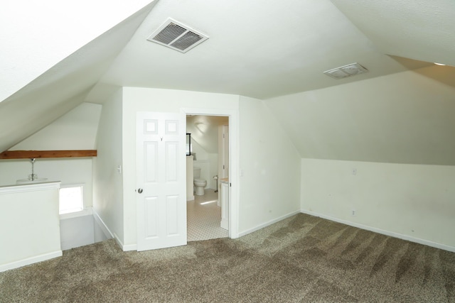 bonus room featuring vaulted ceiling, carpet floors, visible vents, and baseboards