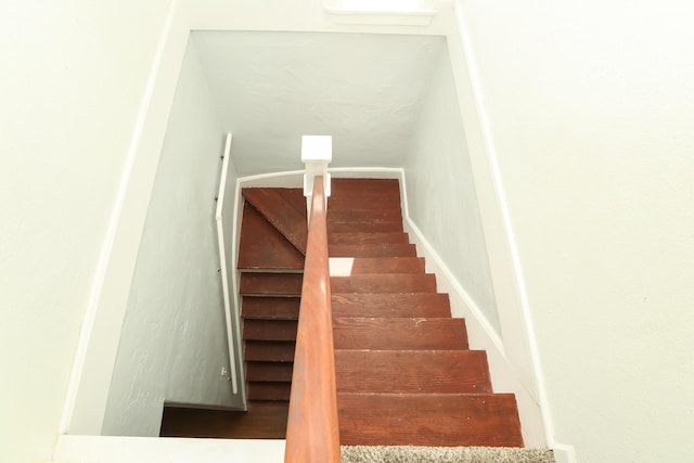 staircase with baseboards and wood finished floors