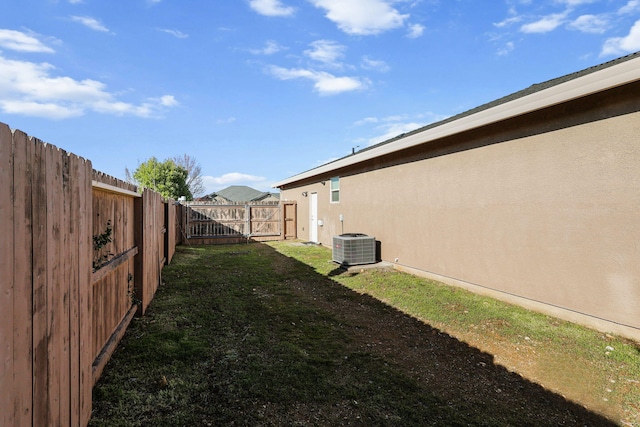 view of yard with a fenced backyard and central AC